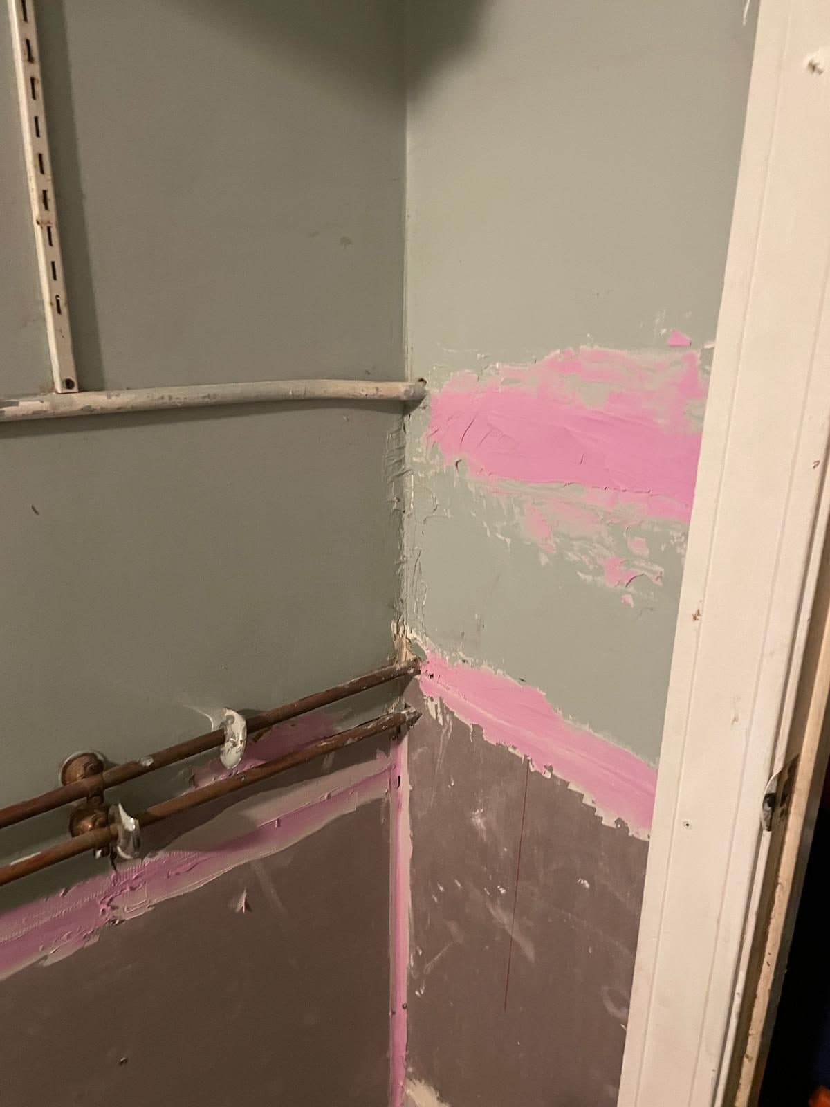 Wall and baseboard patched and primed during a Boston home repair