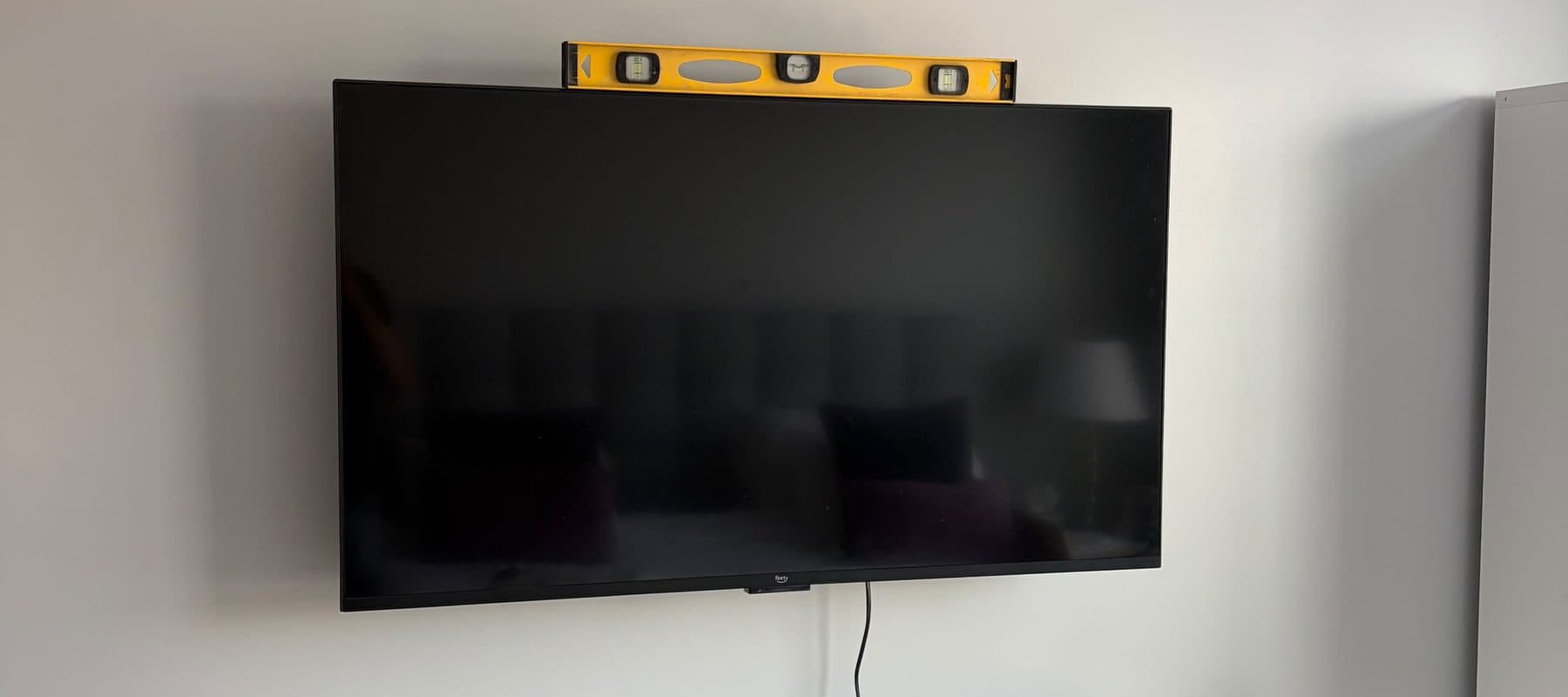 Flat-screen TV wall-mounted and checked level in a Boston apartment